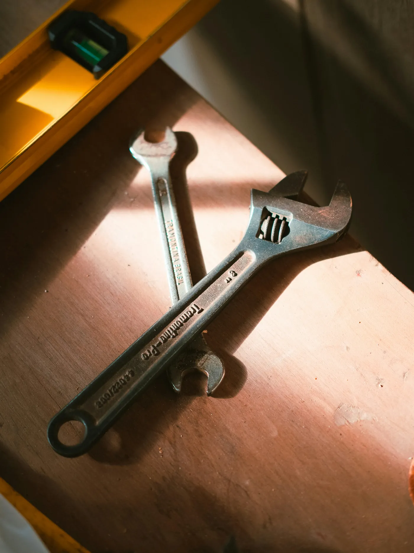 Metal hand tools resting on a wooden work surface